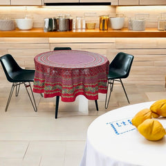 Round Provence-style cotton tablecloth by Le Cluny, featuring a vibrant red background with yellow mimosa and black olive detailing. Measures 70 inches in diameter, made in France, suitable for indoor and outdoor use, and machine washable for easy care.