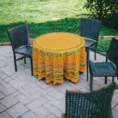 Round Provence-style cotton tablecloth by Le Cluny, featuring a vibrant yellow background with detailed mimosa and black olive patterns. Measures 70 inches in diameter, made in France, suitable for indoor and outdoor use, and machine washable for easy care.