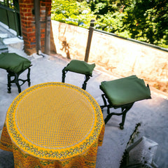 Round Provence-style cotton tablecloth by Le Cluny, featuring a vibrant yellow background with detailed mimosa and black olive patterns. Measures 70 inches in diameter, made in France, suitable for indoor and outdoor use, and machine washable for easy care.