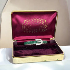 Emerald and clear rhinestone hinged bangle bracelet made of polished stainless steel with a modern belt buckle design, featuring sparkling accents and marked 316L S.Steel, photographed in excellent condition.