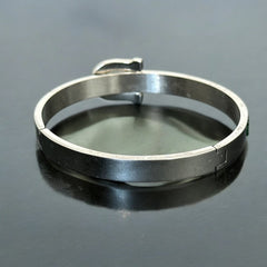 Emerald and clear rhinestone hinged bangle bracelet made of polished stainless steel with a modern belt buckle design, featuring sparkling accents and marked 316L S.Steel, photographed in excellent condition.