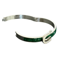 Emerald and clear rhinestone hinged bangle bracelet made of polished stainless steel with a modern belt buckle design, featuring sparkling accents and marked 316L S.Steel, photographed in excellent condition.