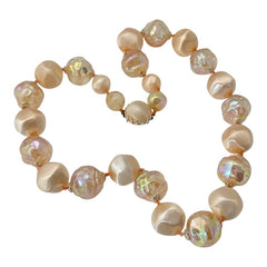 Vintage 1950s/1960s single-strand necklace featuring light peach hollow plastic beads alternating between opaque satin and iridescent transparent beads, finished with a snap clasp adorned with a light peach satin cabochon, signed Japan, in very good vintage condition.