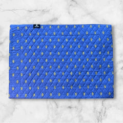 Reversible quilted cotton placemat in Bastide Blue Yellow by Marat d’Avignon, featuring a bold blue floral diamond motif with yellow paisley borders on the front, and a blue background with golden yellow medallions on the reverse, crafted in Provence.