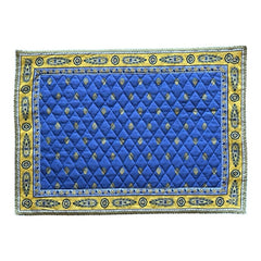 Reversible quilted cotton placemat in Bastide Blue Yellow by Marat d’Avignon, featuring a bold blue floral diamond motif with yellow paisley borders on the front, and a blue background with golden yellow medallions on the reverse, crafted in Provence.