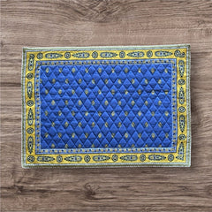 Reversible quilted cotton placemat in Bastide Blue Yellow by Marat d’Avignon, featuring a bold blue floral diamond motif with yellow paisley borders on the front, and a blue background with golden yellow medallions on the reverse, crafted in Provence.