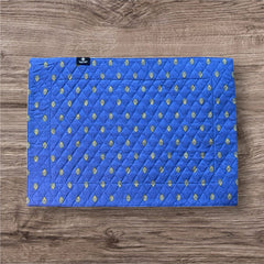 Reversible quilted cotton placemat in Bastide Blue Yellow by Marat d’Avignon, featuring a bold blue floral diamond motif with yellow paisley borders on the front, and a blue background with golden yellow medallions on the reverse, crafted in Provence.