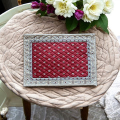 Reversible quilted cotton placemat in Bastide Red Grey by Marat d’Avignon, featuring a deep red floral diamond motif with ornate grey paisley borders on the front, and a delicate red-and-white floral pattern on the reverse, crafted in Provence.