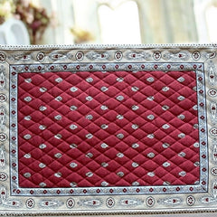 Reversible quilted cotton placemat in Bastide Red Grey by Marat d’Avignon, featuring a deep red floral diamond motif with ornate grey paisley borders on the front, and a delicate red-and-white floral pattern on the reverse, crafted in Provence.