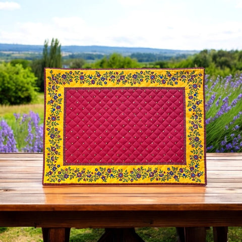 Reversible quilted cotton placemat in Fleurette Red Yellow by Marat d’Avignon, featuring a red diamond-quilted center with petite golden florals and yellow floral scroll borders on the front, and an allover red reverse with golden diamond accents, crafted in Provence.