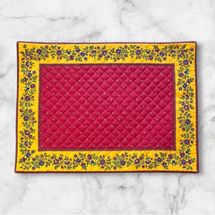 Reversible quilted cotton placemat in Fleurette Red Yellow by Marat d’Avignon, featuring a red diamond-quilted center with petite golden florals and yellow floral scroll borders on the front, and an allover red reverse with golden diamond accents, crafted in Provence.