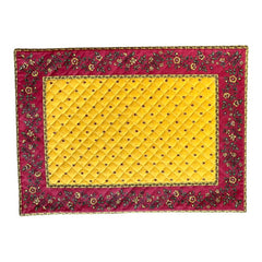 Reversible quilted cotton placemat in Fleurette Yellow Red by Marat d’Avignon, featuring a red diamond-quilted center with petite golden florals and yellow floral scroll borders on the front, and an allover red reverse with red floral accents, crafted in Provence.