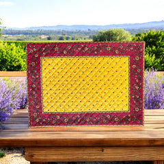 Reversible quilted cotton placemat in Fleurette Yellow Red by Marat d’Avignon, featuring a red diamond-quilted center with petite golden florals and yellow floral scroll borders on the front, and an allover red reverse with red floral accents, crafted in Provence.