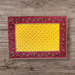 Reversible quilted cotton placemat in Fleurette Yellow Red by Marat d’Avignon, featuring a red diamond-quilted center with petite golden florals and yellow floral scroll borders on the front, and an allover red reverse with red floral accents, crafted in Provence.