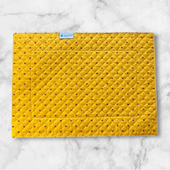 Reversible quilted cotton placemat in Fleurette Yellow Red by Marat d’Avignon, featuring a red diamond-quilted center with petite golden florals and yellow floral scroll borders on the front, and an allover red reverse with red floral accents, crafted in Provence.