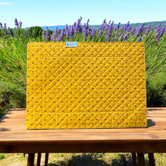 Reversible quilted cotton placemat in Fleurette Yellow Red by Marat d’Avignon, featuring a red diamond-quilted center with petite golden florals and yellow floral scroll borders on the front, and an allover red reverse with red floral accents, crafted in Provence.