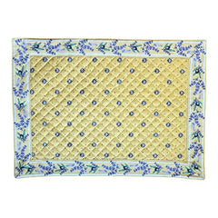 Reversible quilted cotton placemat in Lauris Light Yellow by Marat d’Avignon, featuring a pale yellow center with blue floral medallions and a border of lavender sprigs and olive branches, with a reverse side of soft yellow scattered with tiny blue and white blossoms, crafted in Provence.