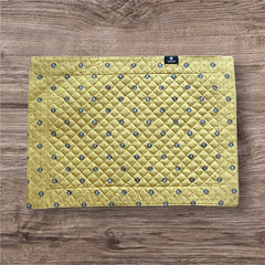 Reversible quilted cotton placemat in Lauris Light Yellow by Marat d’Avignon, featuring a pale yellow center with blue floral medallions and a border of lavender sprigs and olive branches, with a reverse side of soft yellow scattered with tiny blue and white blossoms, crafted in Provence.