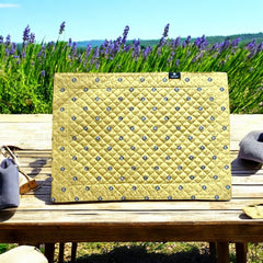 Reversible quilted cotton placemat in Lauris Light Yellow by Marat d’Avignon, featuring a pale yellow center with blue floral medallions and a border of lavender sprigs and olive branches, with a reverse side of soft yellow scattered with tiny blue and white blossoms, crafted in Provence.