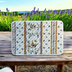 Provence Reversible quilted cotton placemat in Moustiers Red by Tissus Toselli, featuring traditional Provençal motifs inspired by Moustiers ceramics, with two birds in flight, floral garlands, and cream trim.