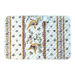 Provence Reversible quilted cotton placemat in Moustiers Red by Tissus Toselli, featuring traditional Provençal motifs inspired by Moustiers ceramics, with two birds in flight, floral garlands, and cream trim.