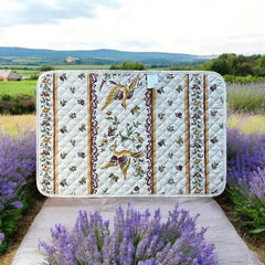 Provence Reversible quilted cotton placemat in Moustiers Red by Tissus Toselli, featuring traditional Provençal motifs inspired by Moustiers ceramics, with two birds in flight, floral garlands, and cream trim.