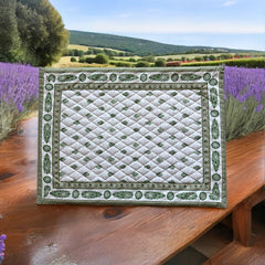Reversible quilted cotton placemat in Bastide Green by Marat d’Avignon, featuring an ivory background with green floral medallions and scrolling vine borders on the front, and a white reverse with scattered green floral sprigs, crafted in Provence.