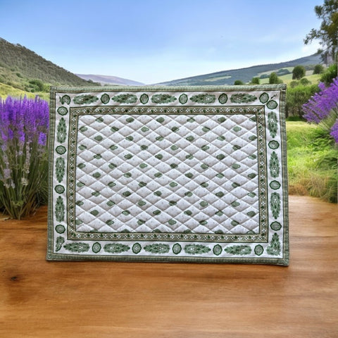 Reversible quilted cotton placemat in Bastide Green by Marat d’Avignon, featuring an ivory background with green floral medallions and scrolling vine borders on the front, and a white reverse with scattered green floral sprigs, crafted in Provence.