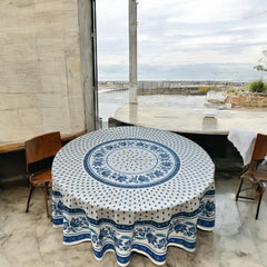 Round Provence-style cotton tablecloth by Le Cluny, featuring a blue and white floral design inspired by French elegance. Coated for easy cleaning, measures 70 inches in diameter, perfect for indoor and outdoor use.