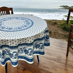 Round Provence-style cotton tablecloth by Le Cluny, featuring a blue and white floral design inspired by French elegance. Coated for easy cleaning, measures 70 inches in diameter, perfect for indoor and outdoor use.