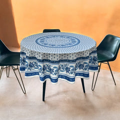 Round Provence-style cotton tablecloth by Le Cluny, featuring a blue and white floral design inspired by French elegance. Coated for easy cleaning, measures 70 inches in diameter, perfect for indoor and outdoor use.