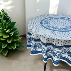 Round Provence-style cotton tablecloth by Le Cluny, featuring a blue and white floral design inspired by French elegance. Coated for easy cleaning, measures 70 inches in diameter, perfect for indoor and outdoor use.