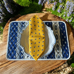 Provence cotton napkins featuring a yellow background with blue and yellow floral designs, part of the Avignon Collection from Marat d’Avignon made of 100% cotton, measuring 18" x 18", with vibrant, fade-resistant prints. Made in France.