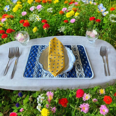 Provence cotton napkins featuring a yellow background with blue and yellow floral designs, part of the Avignon Collection from Marat d’Avignon made of 100% cotton, measuring 18" x 18", with vibrant, fade-resistant prints. Made in France.