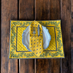 Provence cotton napkins featuring a yellow background with blue and yellow floral designs, part of the Avignon Collection from Marat d’Avignon made of 100% cotton, measuring 18" x 18", with vibrant, fade-resistant prints. Made in France.