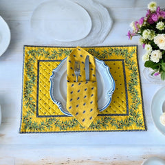 Provence cotton napkins featuring a yellow background with blue and yellow floral designs, part of the Avignon Collection from Marat d’Avignon made of 100% cotton, measuring 18" x 18", with vibrant, fade-resistant prints. Made in France.