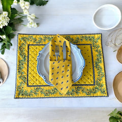 Provence cotton napkins featuring a yellow background with blue and yellow floral designs, part of the Avignon Collection from Marat d’Avignon made of 100% cotton, measuring 18" x 18", with vibrant, fade-resistant prints. Made in France.