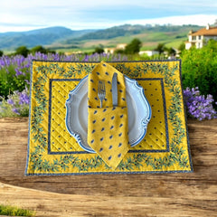 Provence cotton napkins featuring a yellow background with blue and yellow floral designs, part of the Avignon Collection from Marat d’Avignon made of 100% cotton, measuring 18" x 18", with vibrant, fade-resistant prints. Made in France.