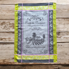 French Provence tea towel featuring the Rosé de Provence Appellation Contrôlée design, showcasing a vineyard and winery in elegant cotton. Available in orange with yellow accents and green with soft purple and gray details. Decorative and eco-friendly kitchen decor.