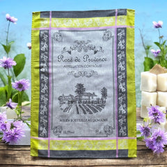 French Provence tea towel featuring the Rosé de Provence Appellation Contrôlée design, showcasing a vineyard and winery in elegant cotton. Available in orange with yellow accents and green with soft purple and gray details. Decorative and eco-friendly kitchen decor.