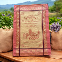 French Provence tea towel featuring the Rosé de Provence Appellation Contrôlée design, showcasing a vineyard and winery in elegant cotton. Available in orange with yellow accents and green with soft purple and gray details. Decorative and eco-friendly kitchen decor.