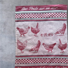 Provence tea towel featuring a Poule design with hens and chicks, woven in red and natural tones with eggplant-colored stripes and a checkered pattern. Includes the French children's song 'Une poule sur un mur qui picorait du pain dur.' Made of 100% cotton, perfect for decorative kitchen use.