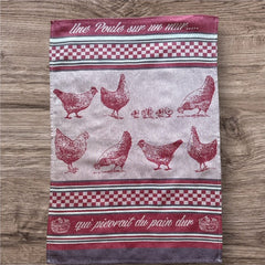 Provence tea towel featuring a Poule design with hens and chicks, woven in red and natural tones with eggplant-colored stripes and a checkered pattern. Includes the French children's song 'Une poule sur un mur qui picorait du pain dur.' Made of 100% cotton, perfect for decorative kitchen use.