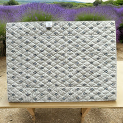 Reversible quilted cotton placemat in Bastide Blue Floral by Marat d’Avignon, featuring a soft blue and grey floral diamond motif on one side and a coordinating striped pattern on the reverse, crafted in Provence.