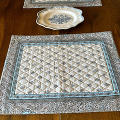 Reversible quilted cotton placemat in Bastide Blue Floral by Marat d’Avignon, featuring a soft blue and grey floral diamond motif on one side and a coordinating striped pattern on the reverse, crafted in Provence.