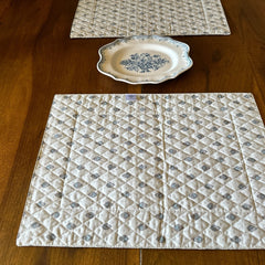 Reversible quilted cotton placemat in Bastide Blue Floral by Marat d’Avignon, featuring a soft blue and grey floral diamond motif on one side and a coordinating striped pattern on the reverse, crafted in Provence.