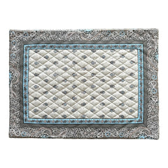 Reversible quilted cotton placemat in Bastide Blue Floral by Marat d’Avignon, featuring a soft blue and grey floral diamond motif on one side and a coordinating striped pattern on the reverse, crafted in Provence.
