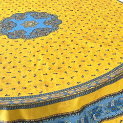 Round Provence-style coated cotton tablecloth by Marat d'Avignon, featuring a vibrant yellow background with blue and white floral patterns. Measures 70 inches in diameter, perfect for indoor and outdoor use, and easy to clean.