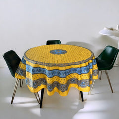 Round Provence-style coated cotton tablecloth by Marat d'Avignon, featuring a vibrant yellow background with blue and white floral patterns. Measures 70 inches in diameter, perfect for indoor and outdoor use, and easy to clean.