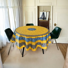 Round Provence-style coated cotton tablecloth by Marat d'Avignon, featuring a vibrant yellow background with blue and white floral patterns. Measures 70 inches in diameter, perfect for indoor and outdoor use, and easy to clean.